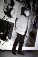 Andy Warhol - Schwarz-weiß-Foto,A.W. stehend vor Bilderwand II, 20,5 x 30,5 cm, 14. November 1980 in Stuttgart verkocht voor € 45!