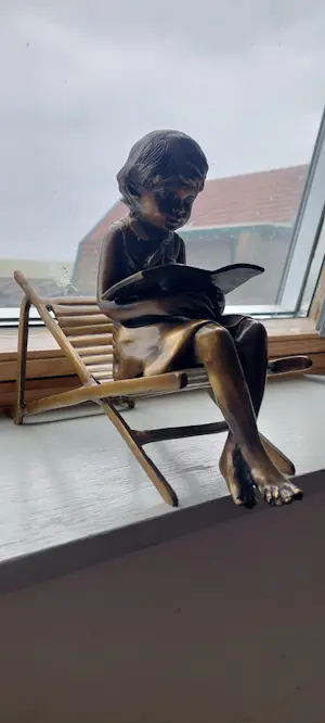 Brons (Onbekend) - Bronzen beeld; zittend meisje met boek, op strandstoel kopen? Bied vanaf 150!