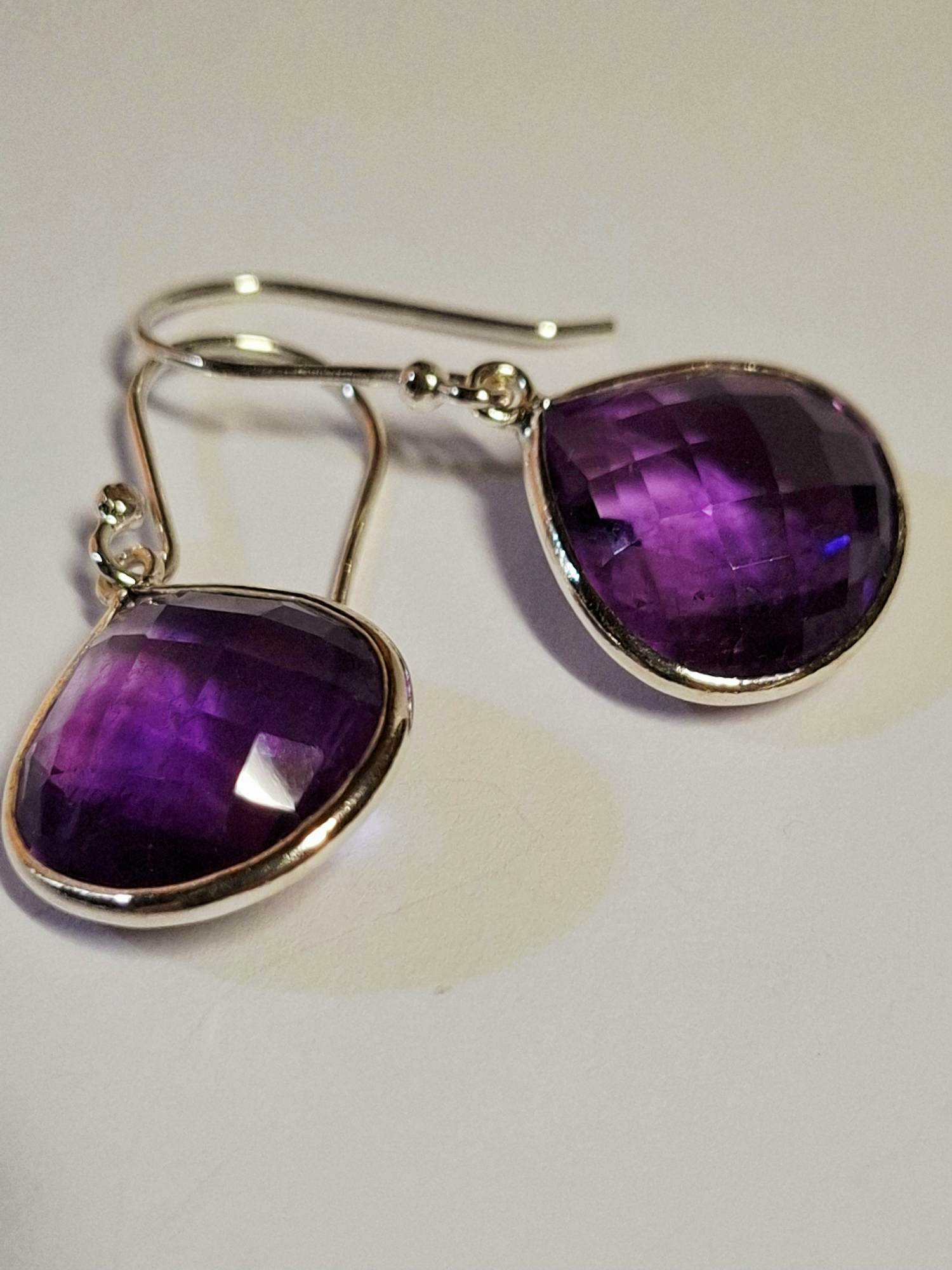 nieuzilveren oorbellen, elk met  aan beide zijden gefacetteerde paarse amethist verkocht voor € 40!