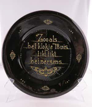 Amstelhoek - Zwart geglazuurd aardewerk, Bord met spreuk verkocht voor € 10!