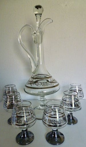 Niet of onleesbaar gesigneerd - Elegante decanter / karaf op voet met 6 cognac glazen met verzilverde decoratie. kopen? Bied vanaf 1!