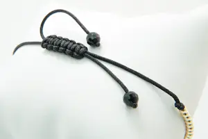 60 - Fijn gedeeltelijk gouden 14krt armband met steentjes en zwart koord kopen? Bied vanaf 230!