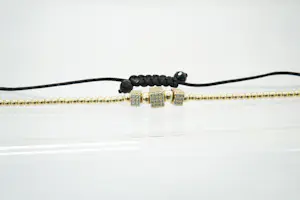 60 - Fijn gedeeltelijk gouden 14krt armband met steentjes en zwart koord kopen? Bied vanaf 230!