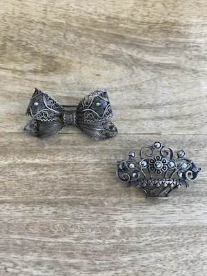 AcheterEen Lotje van twee zilveren geoxideerde broches in een bloemenmand en strik.? Enchérissez de 19!