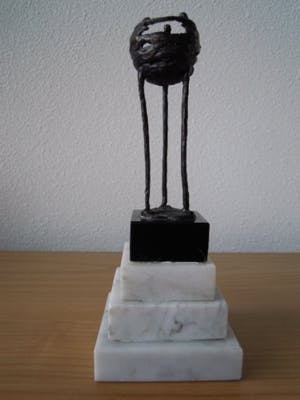 Corry Ammerlaan - Beeldje op hoge sokkel met 3 figuren die elkaar vast houden. kopen? Bied vanaf 15!