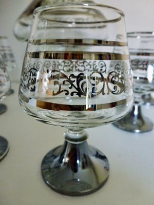 Niet of onleesbaar gesigneerd - Elegante decanter / karaf op voet met 6 cognac glazen met verzilverde decoratie. kopen? Bied vanaf 1!
