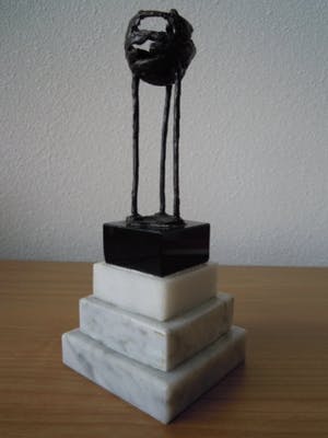 Corry Ammerlaan - Beeldje op hoge sokkel met 3 figuren die elkaar vast houden. kopen? Bied vanaf 15!