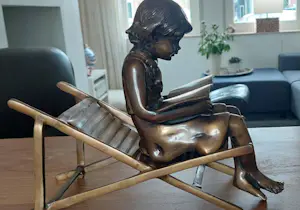 Brons (Onbekend) - Bronzen beeld; zittend meisje met boek, op strandstoel kopen? Bied vanaf 150!