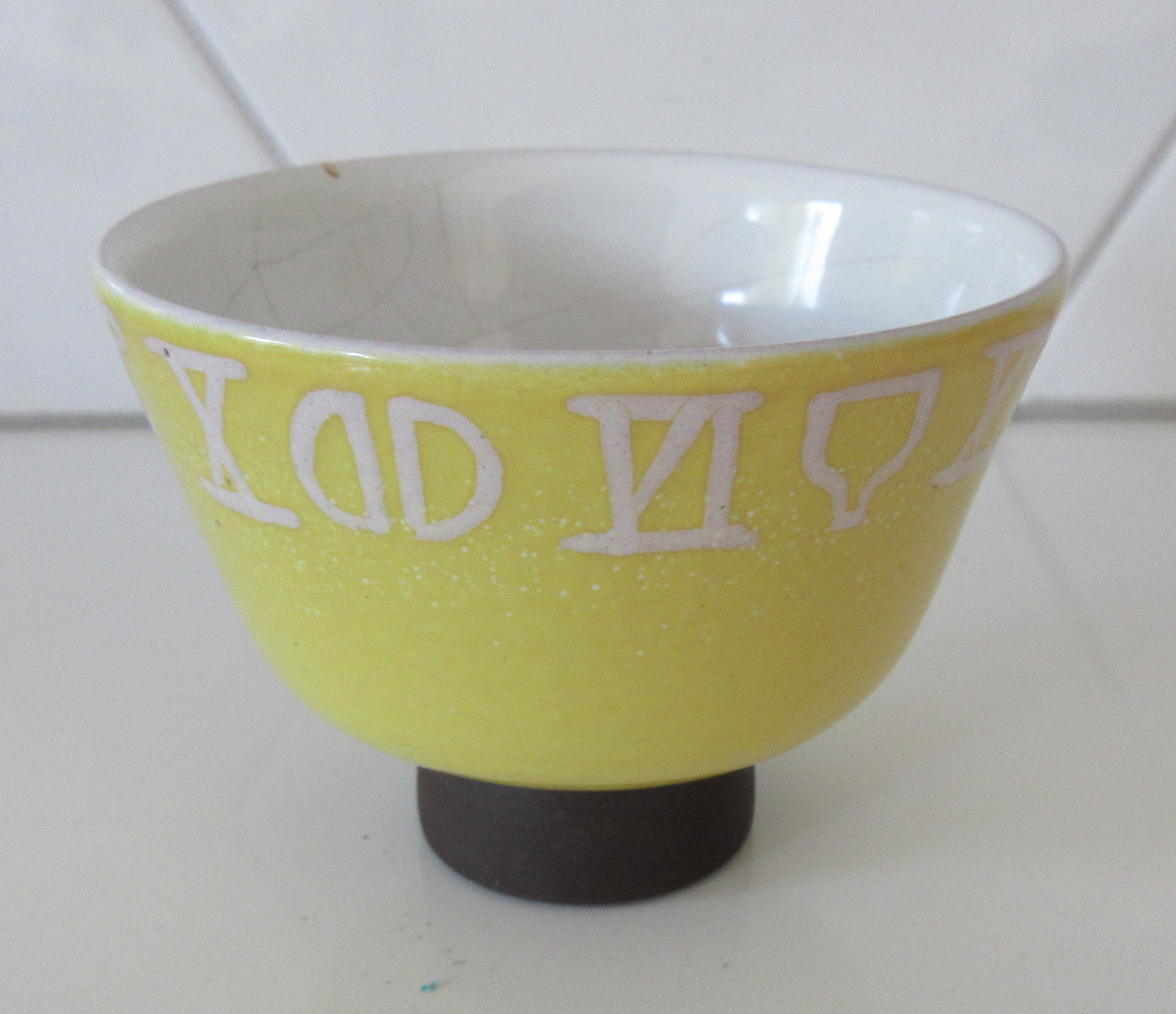 Niet of onleesbaar gesigneerd - Fifties zachtgeel kunstaardewerken schaaltje op bruine ronde voet kopen? Bied vanaf 1!