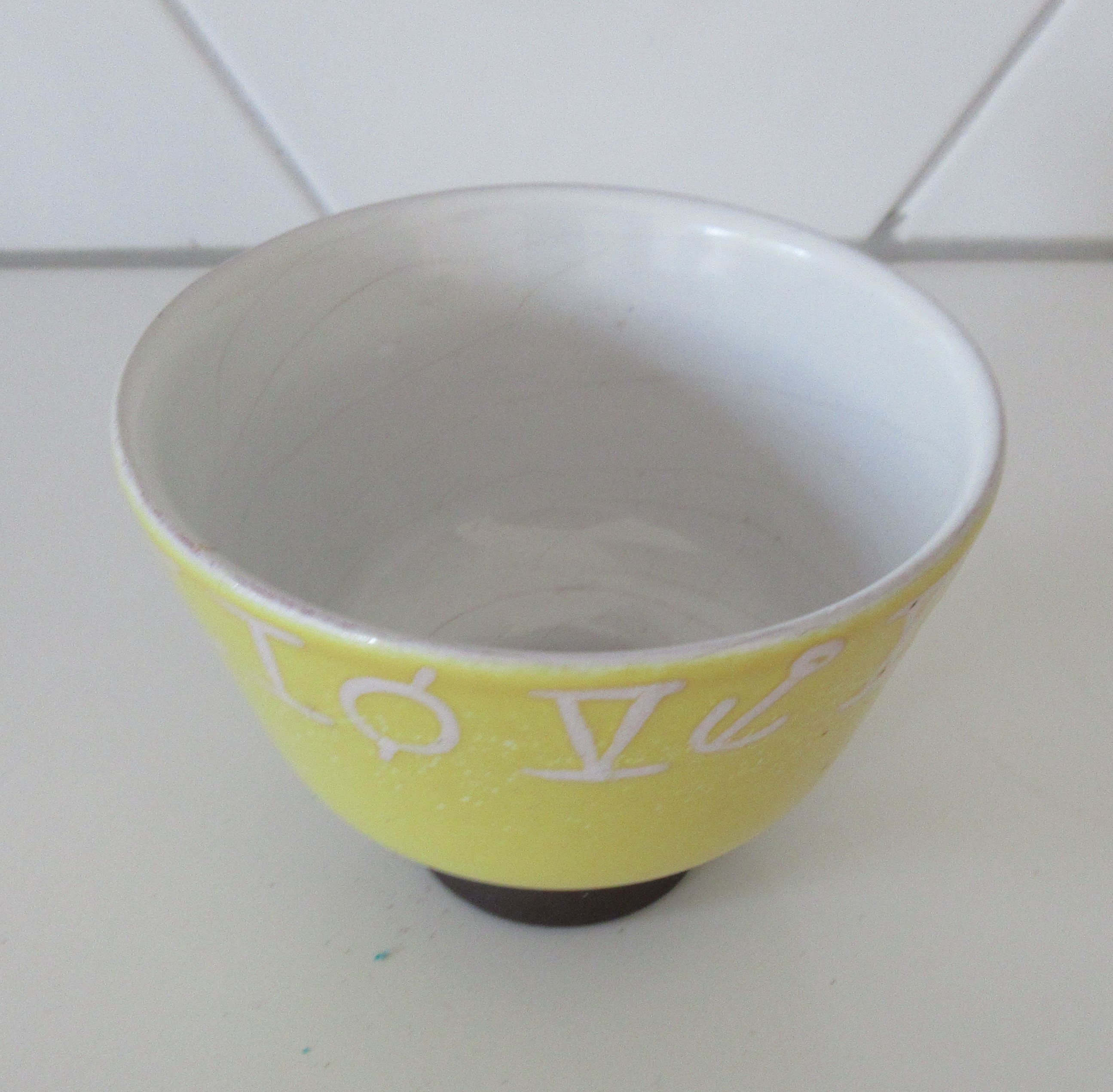 Niet of onleesbaar gesigneerd - Fifties zachtgeel kunstaardewerken schaaltje op bruine ronde voet kopen? Bied vanaf 1!