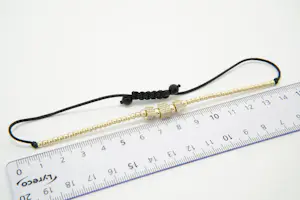 60 - Fijn gedeeltelijk gouden 14krt armband met steentjes en zwart koord kopen? Bied vanaf 230!