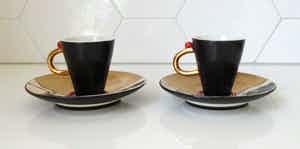 Niet of onleesbaar gesigneerd - Twee Studio Keramische kop- en schotels "Koeien met bellen" verkocht voor € 10!