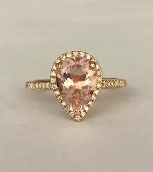 AcheterRing van 18 karaats roségoud met peervormige morganiet en halo van diamanten? Enchérissez de 700!