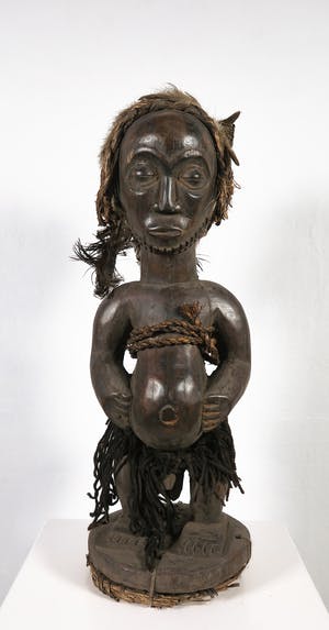 Kusu - Houten beschermbeeld met ringbaard, een kapsel van haar en veren met rugbuidel kopen? Bied vanaf 1!