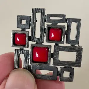 Niet of onleesbaar gesigneerd - Brutalistische metalen broche voorzien van drie geslepen stuks bloedkoraal kopen? Bied vanaf 1!