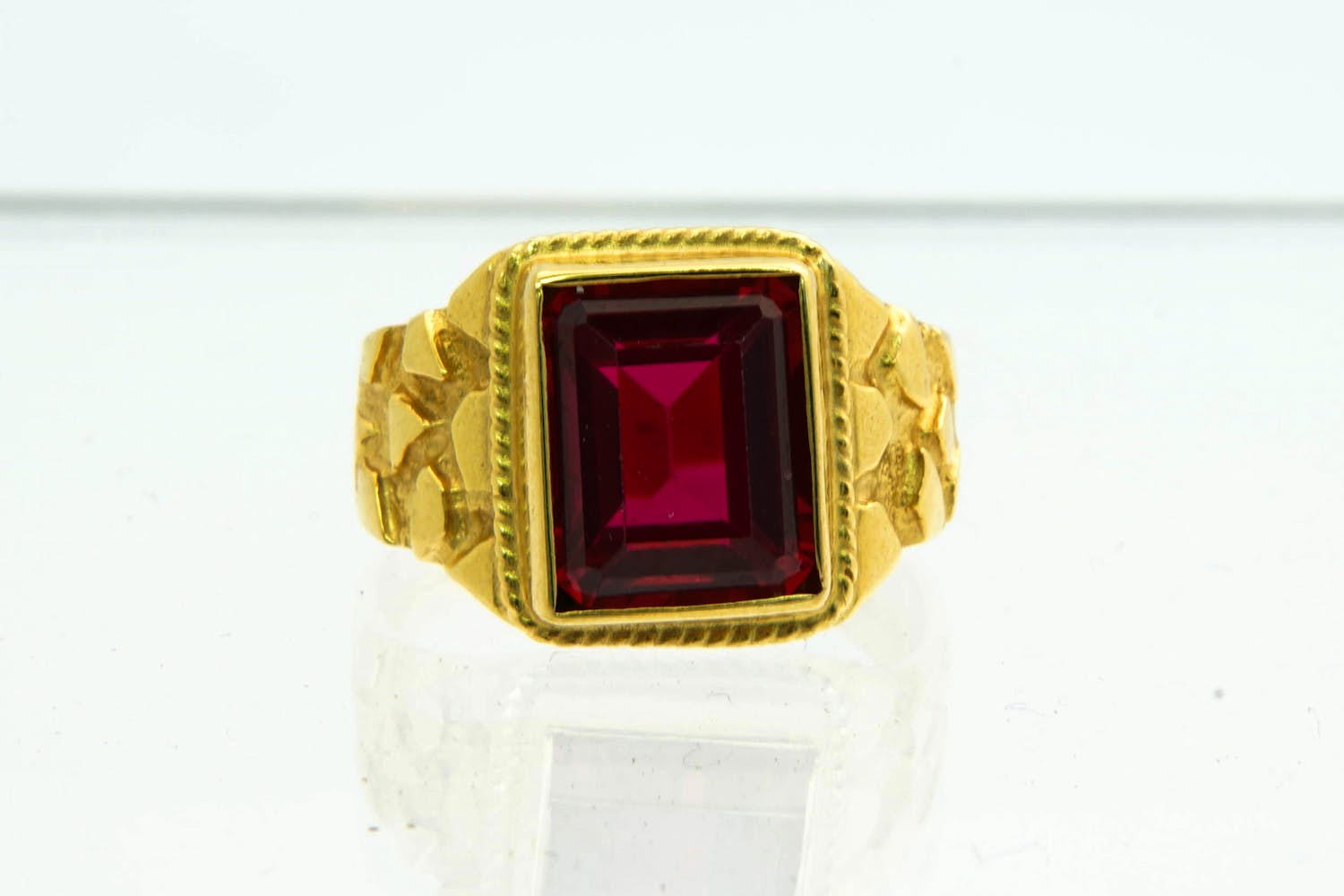 1- Mooi bewerkte 18 krt geel gouden ring met gefacetteerde  rode kleursteen kopen? Bied vanaf 290!